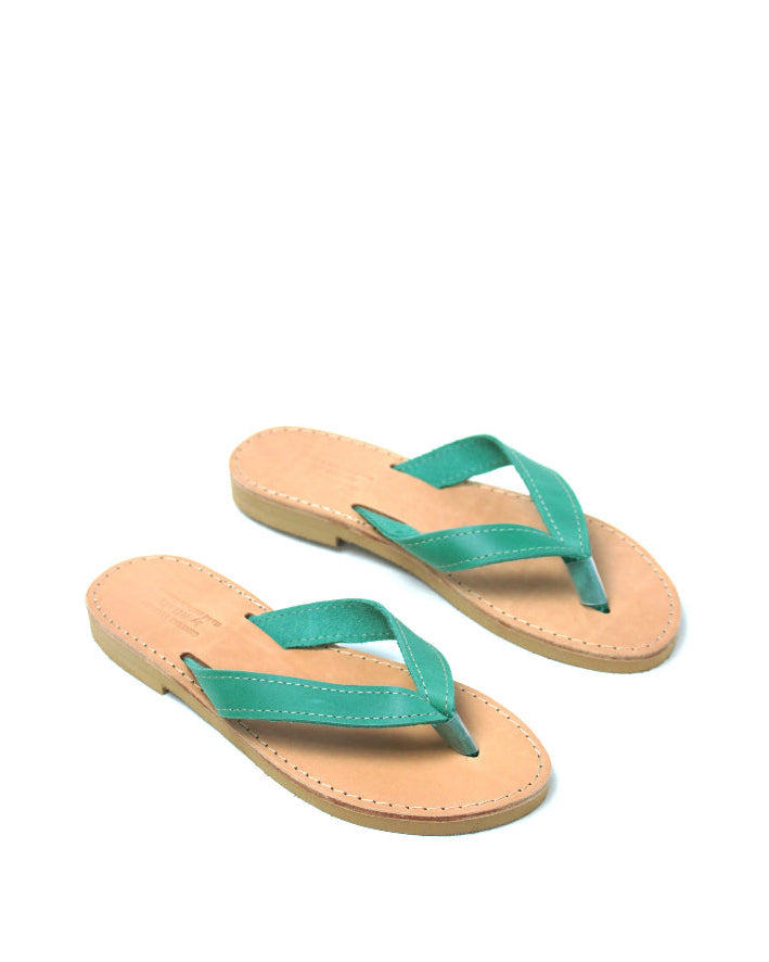Pair of flip-flops with green straps on a white background