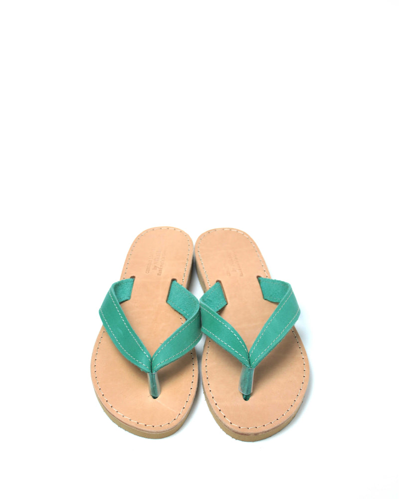 Pair of flip-flops with green straps on a white background