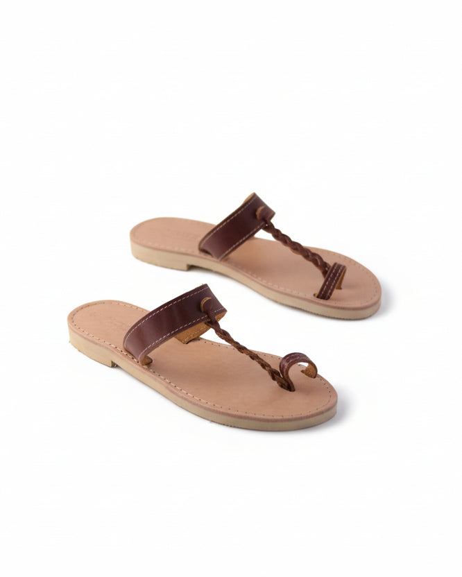 Pair of tan sandals with brown straps on a white background